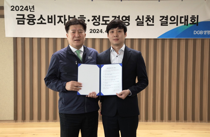 김성한 대표이사(왼쪽)와 DGB생명 임직원 대표가 금융소비자보호 준수 서약서 선창 후 기념사진 촬영을 하고있다.