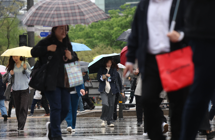 서울 광화문광장에서 시민들이 우산쓴 채 걸어가고 있다.연합뉴스