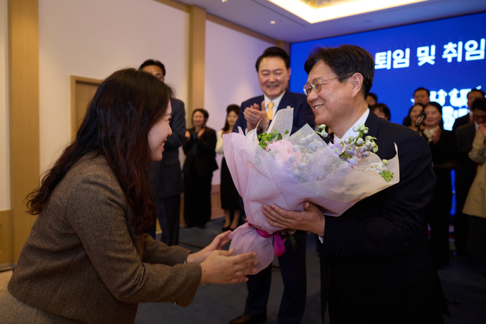 윤석열 대통령이 23일 서울 용산 대통령실 청사 비서실장 교체 행사에 참석해 직원으로부터 꽃다발을 받는 이관섭 전임 비서실장을 보며 박수 치고 있