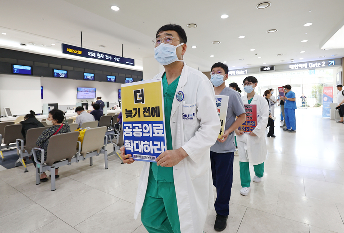 서울 종로구 서울대병원에서 공공운수노조 의료연대 서울대병원 분회 조합원들이 정부에 공공의료 대책 마련과 의사 증원 등을 촉구하는 피켓을 든