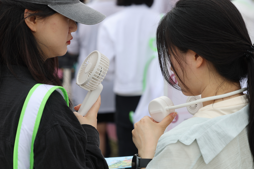 더운 날씨가 이어진 22일 서울 용산구 노들섬에서 열린 체험형 뷰티&헬스(Beauty&Health) 축제 '2025 올리브영 페스타'에서 참관객들이 휴대용 선풍기로
