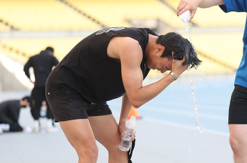 대구 낮 최고기온이 33.4도까지 오른 20일 대구스타디움에서 열린 대구시 재난안전기동대 채용 체력 검정을 마친 한 응시자가 시원한 물로 세수하고 있