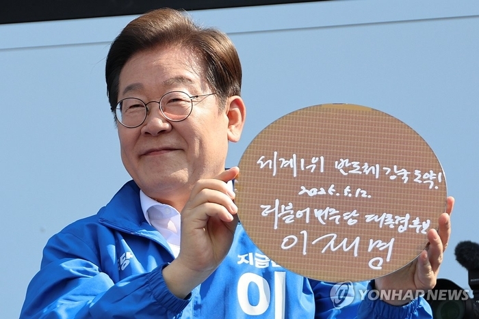 이재명 대통령이 선거 공식 운동 첫날인 지난달 12일 경기도 화성시를 찾아 '세계1위 반도체 강국 도약!'이라고 쓴 반도체 웨이퍼를 들고 기념 촬영