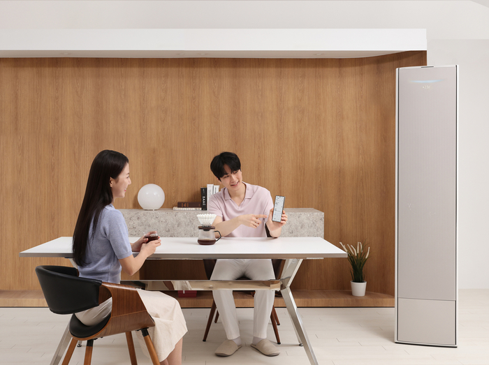 삼성전자 모델이 'AI 쾌적', 'AI 절약모드' 등 다양한 AI 기능을 갖춘 2025년 에어컨을 체험하고 있다.