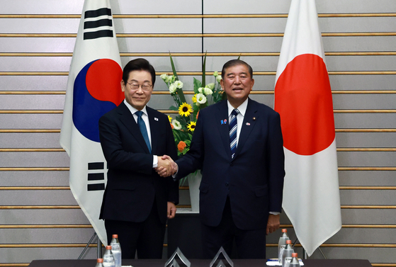 이재명(왼쪽) 대통령과 이시바 시게루 일본 총리가 23일 일본 도쿄 총리 관저에서 열린 한일 확대정상회담에 앞서 기념촬영을 하며 악수하고 있다. 연