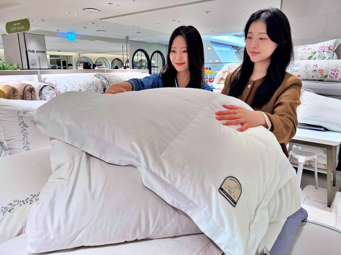 롯데백화점 본점 8층 홈패션 매장에서 구스침구를 홍보하고 있는 모델의 모습. 사진=롯데백화점