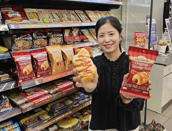 모델이 CU가 미국 유명 육가공업체 '쟌슨빌'과 협업해 출시한 소시지 롤빵을 소개하고 있다. 사진=BGF리테일