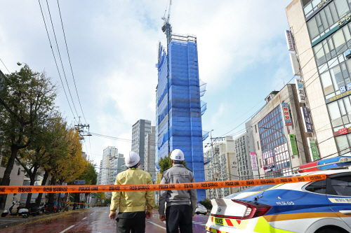 기울어진 공사장 구조물 인근 시민 출입 통제하는 경찰