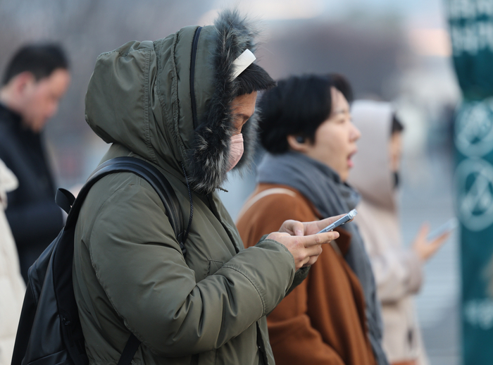 서울 종로구 광화문네거리에서 두꺼운 외투를 입고 횡단보도 신호를 기다리는 출근길 시민들.연합뉴스