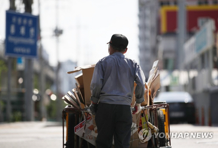 무더위 속 폐지 수레 미는 노인