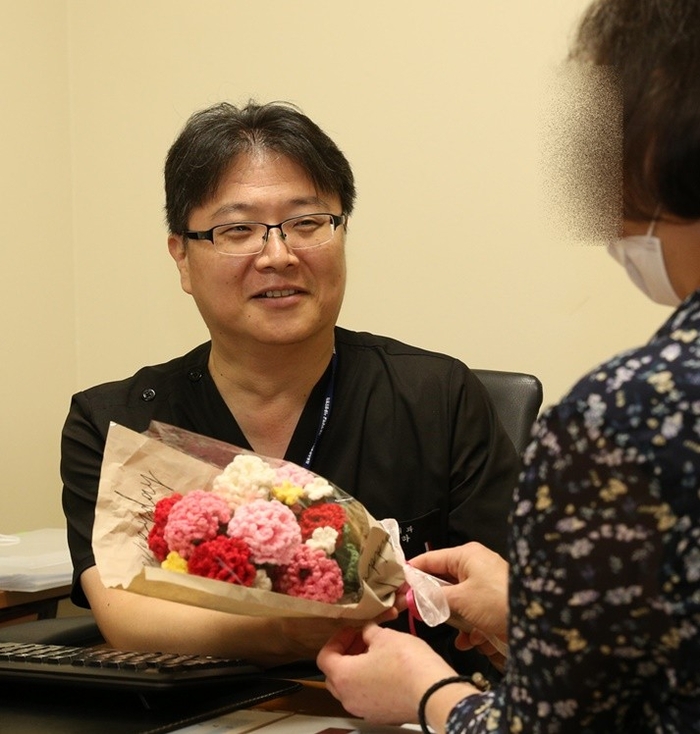두 번째 신장이식 수술로 말기신부전을 극복한 환자가 건강을 되찾은 뒤, 정병하 교수(왼쪽)에게 자신이 뜨개질로 만든 카네이션 꽃다발을 전하고 있