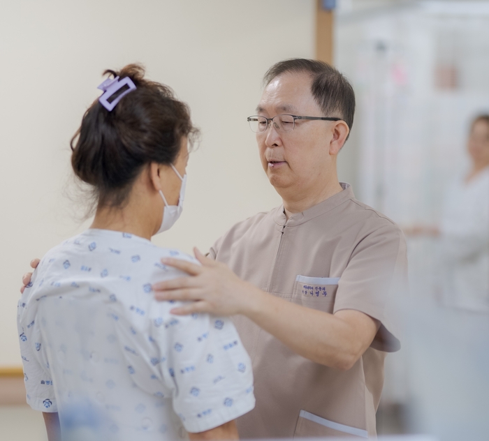 통증과의 싸움에서는 긍정의 마음과 내일에 대한 희망을 갖는 것이 중요하다. 나영무 원장(오른쪽)이 아침 회진 시간에 입원환자에게 바른 자세와 함