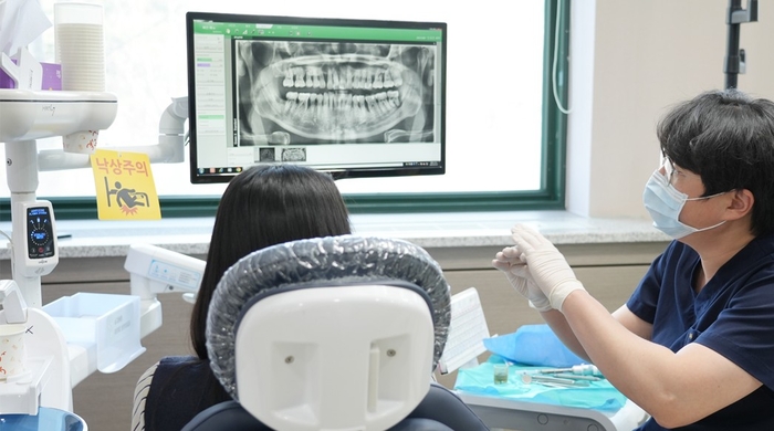 분당제생병원 치과센터 선화경 과장이 환자에게 잇몸과 치아의 상태를 설명하고있다.