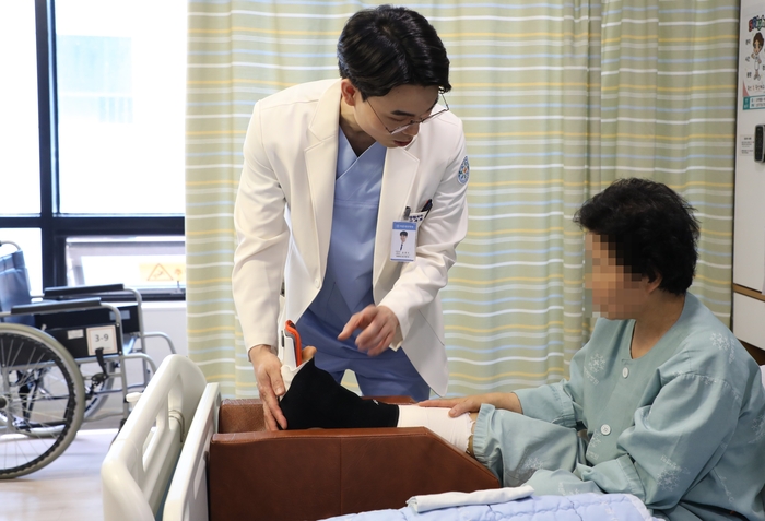 바른세상병원 수족부센터 윤영식 원장이 무지외반증 수술 후 회복중인 환자의 상태를 확인하고 있다. 사진=바른세상병원