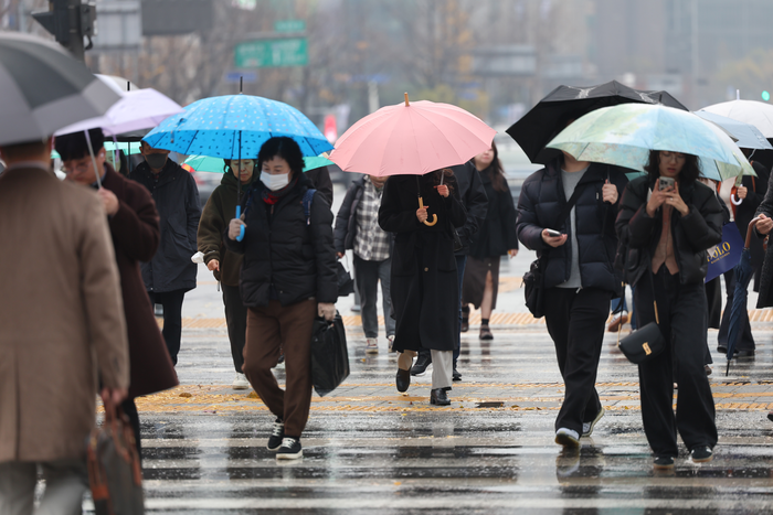 지난 25일 서울 종로구 광화문네거리에서 우산을 쓴 시민들이 이동하고 있다.