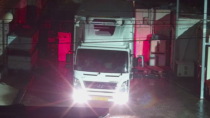 물품 납품을 하는 중 환하게 라이트를 주민의 집으로 비추고 있다.