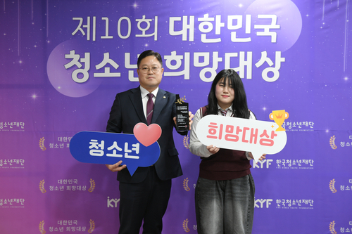 시상자로 나선 양주 옥정중학교 김홍정 학생(오른쪽)이 18일 '2025년 제10회 대한민국 청소년 희망대상'을 김현수 양주시의회 의원에게 건네고 있다