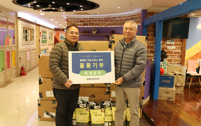 인천도시가스 이상규 상무이사(우측)가 해피홈보육원 이성일 원장에게 동계점퍼를 전달한 뒤 기념촬영을 하고 있다.