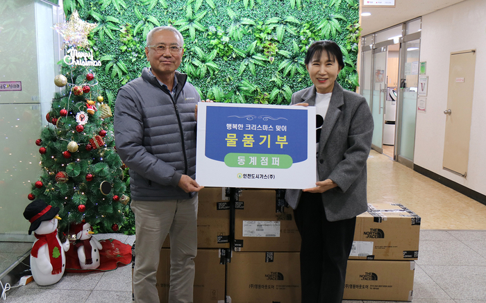 인천도시가스 이상규 상무이사(좌측)가 파인트리홈 김주리 원장에게 
동계점퍼를 전달한 뒤 기념촬영을 하고 있다.