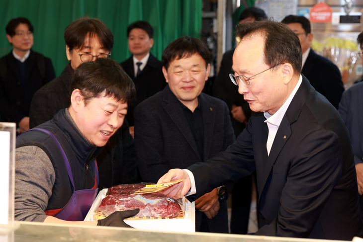 11일 망원시장에서 열린 '2026 설맞이 전통시장 사랑나눔' 행사에서 이환주 KB국민은행장이 식료품을 구입하고 있다.