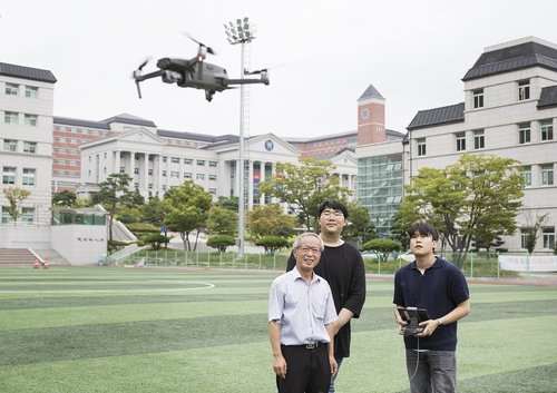 김도열 경복대학교 드론건설환경과 학과장(왼쪽)과 재학생들 드론 비행 실습