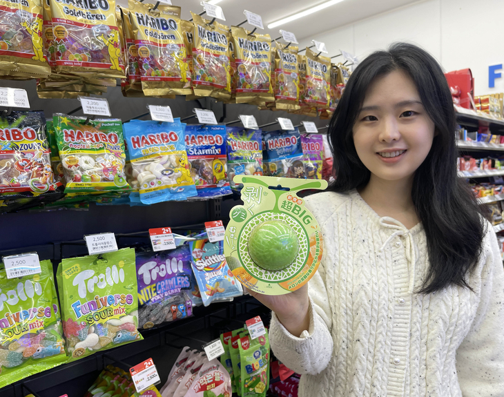 고객이 GS25와 돈키호테가 함께 개발한 '초BIG!무쿠점보멜론구미' 상품을 들고 포즈를 취하고 있다. 사진=GS리테일