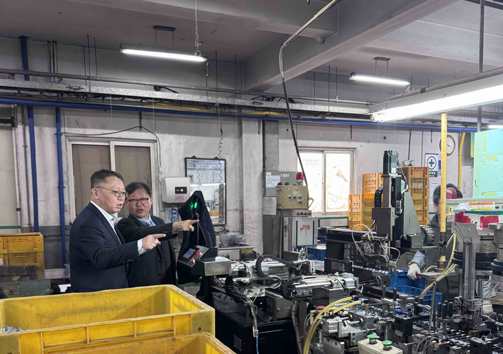 우리은행 정진완 은행장(왼쪽)이 국내 중소기업을 방문해 생산 현장에 대해 관계자로부터 설명을 듣고 있다.