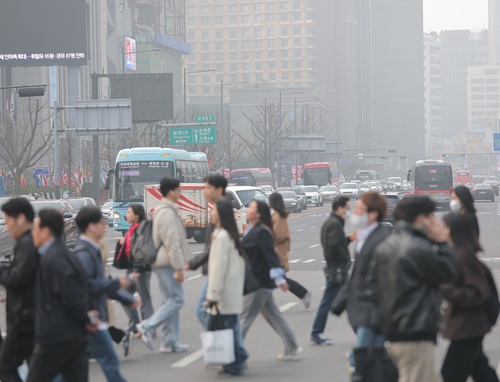 미세먼지 농도가 '나쁨' 수준을 보이는 27일 서울 광화문 세종대로 사거리에서 시민들이 마스크를 쓴 채 걸어가고 있