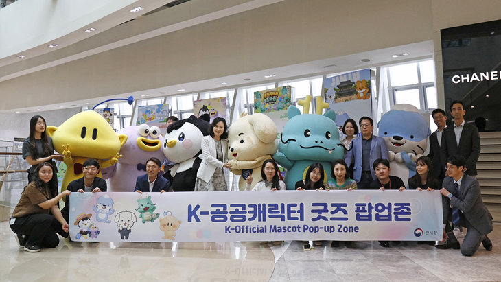 ▲ 서울 롯데면세점 월드타워점에 마련된 'K-공공캐릭터 굿즈 팝업존'에서 외국인 관광객들이 용인시 대표 캐릭터 '조아용' 인형을 살펴보고 있