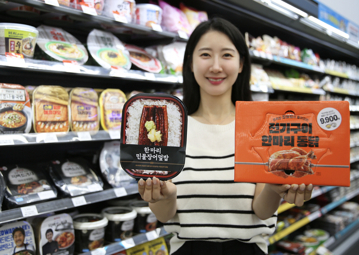 모델이 GS25가 선보인 간편 보양식 '한마리민물장어덮밥'과 '전기구이한마리통닭'을 들고 포즈를 취하고 있다. 사진=GS리테일
