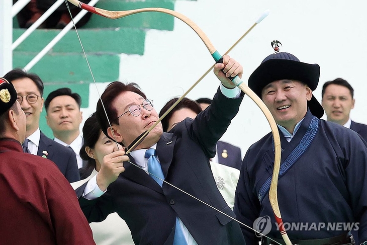 몽골을 국빈방문 중인 이재명 대통령이 11일(현지시간) 울란바타르 나담축제장에서 전통 활을 쏘고 있다. 오른쪽은 오흐나 후렐수흐 몽골 대통령. [사