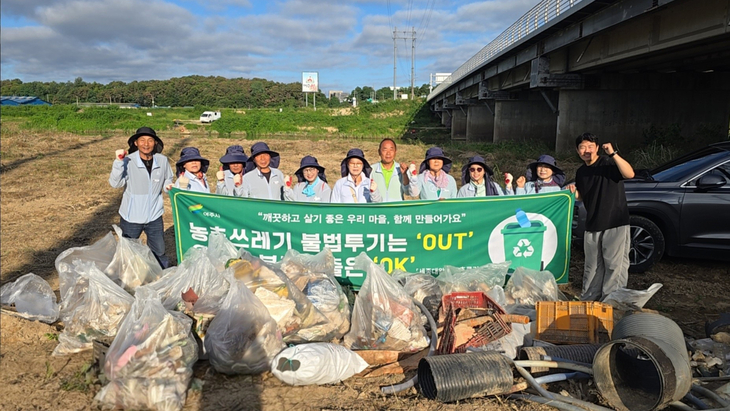 여주시 클린농촌단이 농어촌 쓰레기 수거 지원사업의 일환으로 환경정화 활동을 펼친 뒤 수거한 폐기물 앞에서 기념촬영을 하고 있다. 제공=여주시