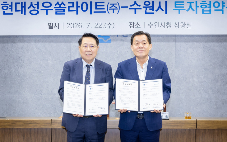 이재준 수원시장(왼쪽)과 현대성우쏠라이트 윤형석 사장이 22일 투자협약을 체결한 뒤 협약서를 들어 보이고 있다. 제공=수원시