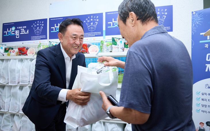 이충우 여주시장이 구세군여주기초푸드뱅크에서 열린 '그냥드림사업' 개소식에서 시민에게 식료품·생필품 꾸러미를 전달하고 있다. 제공=여주시