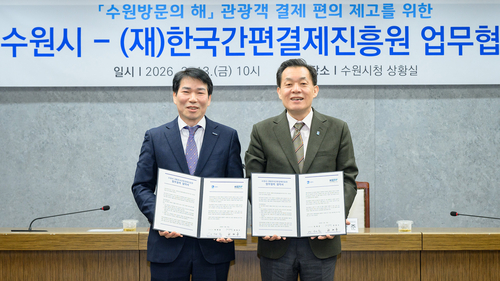 지난 3월 이재준 수원이 시장(오른쪽)이 관광객 결제 편의 제고를 위한 업무협약 후 협약서를 들어보이고 있다. 제공=수원시