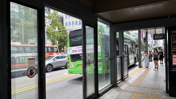 9일 서울특별시 마포구 홍대입구역 앞 버스 정류장. 자동문이 설치되어 있지만, 모든 문이 열린 상태로 있었다. 내부에는 에어컨이 가동되고 있다. [사