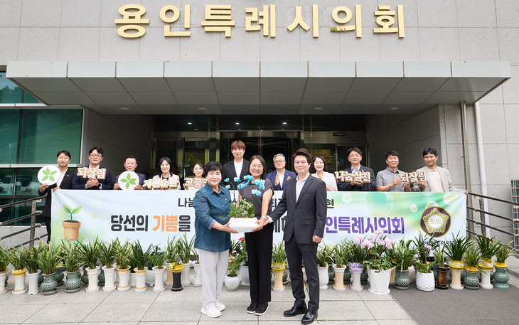 장정순 용인시의회 의장(앞줄 왼쪽)이 20일 시의회 앞에서 관계자들과 함께 아름다운가게 측에 개원 축하 화분을 전달하고 있다. 제공=용인시의회