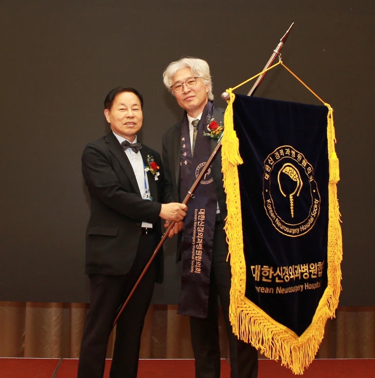 대한신경외과병원협의회 박진규 회장(왼쪽)이 지난 23일 열린 학술대회 및 총회에서 박철웅 신임 회장에게 협의회기를 이양하고 있다. 사진=대한신경