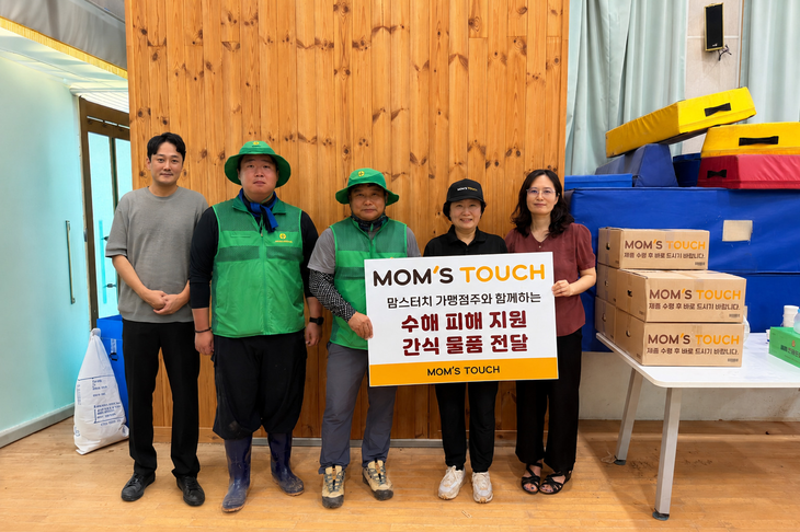 지난 25일 경남 거제시 거제 장평초등학교 집중호우 피해현장에서 맘스터치 본사 임직원 및 가맹점주들이 간식 물품을 전달했다. (왼쪽부터) 유성재 맘