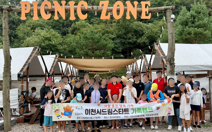 지난 27일 이천시 드림스타트 가족캠프 '사랑충전 행복가득'에 참여한 24가구 79명의 아동과 보호자들이 현수막을 들고 기념 촬영을 하고 있다. 제공=