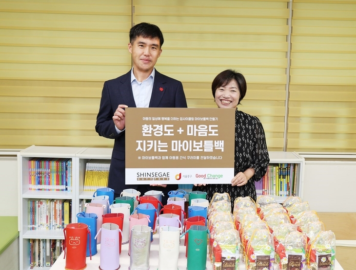 지난 28일 서울 중구 중림키움센터에서 진행된 업사이클링 마이보틀백과 간식 꾸러미 기부 전달식에서 김두량 신세계면세점 CSR팀장(왼쪽)과 정선윤 중