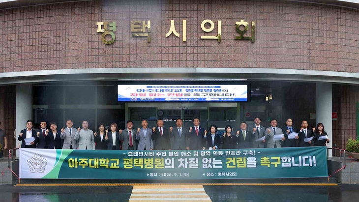 평택시의회 최재영 의장과 시의원들이 의회 본관 앞에서 '아주대학교 평택병원의 차질 없는 건립을 촉구합니다!' 현수막을 들고 구호를 외치고 있