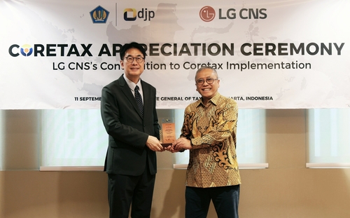 김홍근 LG CNS 디지털비즈니스사업부장 부사장(왼쪽)과 이완 드주니아르디 인도네시아 재무부장관 특별보좌관이 감사패 수여식에서 기념촬영을 하고 