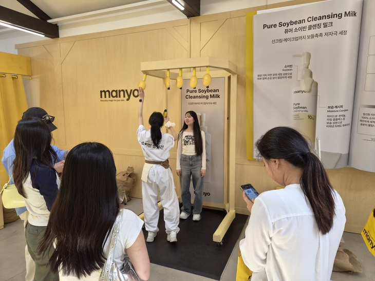 외국인 관광객들이 마녀공장 팝업스토어에서 '소이빈 수확' 게임을 하고 있다. 사진=여헌우 기자.