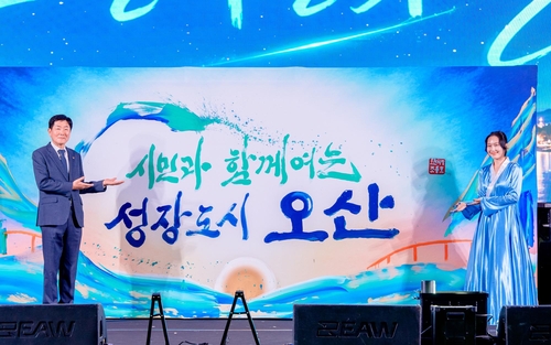 조용호 오산시장(왼쪽)이 제38회 오산시민의 날 행사에서 글씨당 김소영 작가가 완성한 '시민과 함께 여는 성장도시 오산' 캘리그라피 작품을 선보