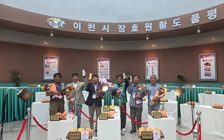 제30회 이천시 장호원황도 품평회 수상자들이 장호원농산물유통센터 전시장에서 수상작과 함께 기념촬영을 하고 있다. 제공=이천시