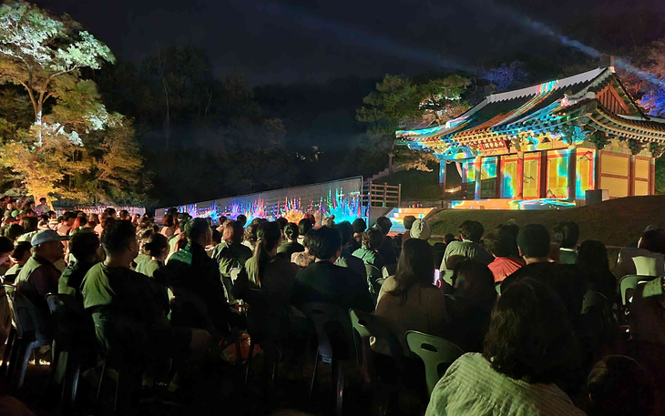추석 연휴 기간 '2026 국가유산 미디어아트 강화 고려궁지'를 찾은 관람객들이 외규장각을 배경으로 펼쳐지는 미디어아트를 관람하고 있다. 제공=강