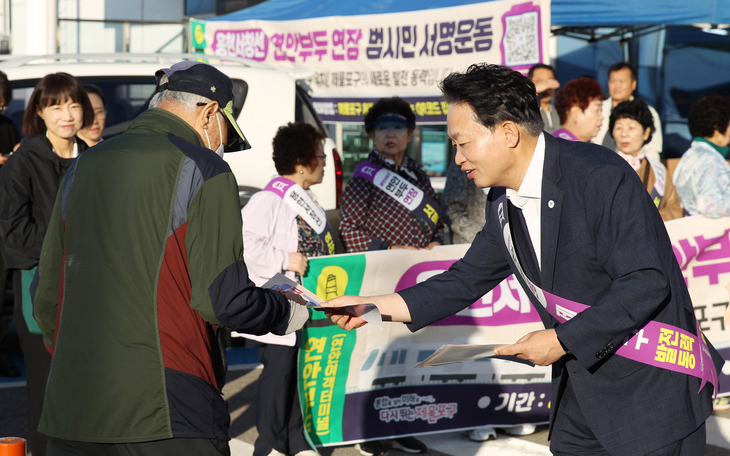 김찬진 제물포구청장이 7일 인천항연안여객터미널에서 시민에게 홍보물을 건네며 용현서창선 연안부두 연장 범시민 서명 참여를 독려하고 있다. 제공