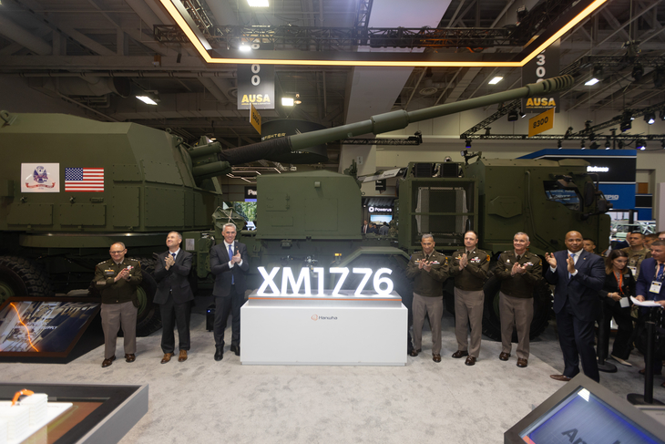 미국 육군으로부터 'XM1776'이라는 제식 명칭을 받은 K-9 차륜형 자주포 앞에서 관계자들이 기념 사진을 촬영하고 있다. 사진=한화에어로스페이스