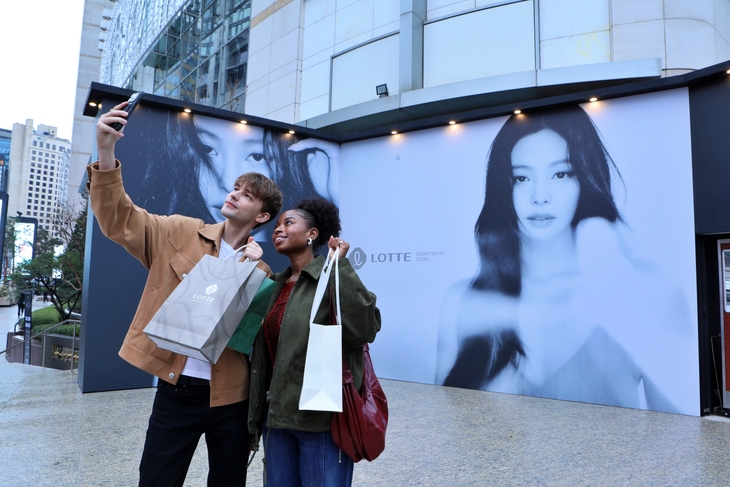 오는 18일까지 롯데백화점 본점 앞 '더 스테이지'에서 운영되는 제니 포토스팟에서 외국인 관광객들이 기념 사진을 찍고 있다. 사진=롯데백화점